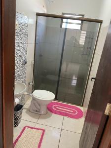 ein Badezimmer mit Toilette und Glasdusche in der Unterkunft Sua casa em Dourados in Dourados + 3 Fotos