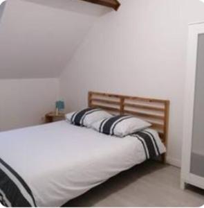 a bedroom with a bed with two pillows on it at Cottage 3 à la ferme in La Croix-en-Brie