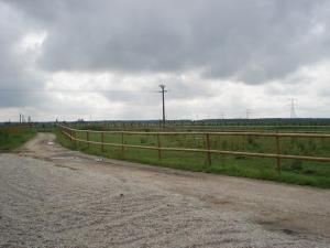 a dirt road with a fence next to a field at Cottage 3 à la ferme in La Croix-en-Brie