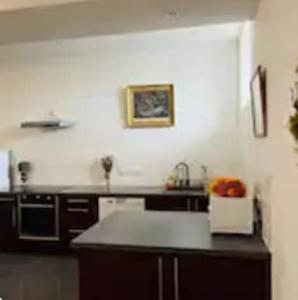 a kitchen with a black counter top in a room at Cottage 3 à la ferme in La Croix-en-Brie