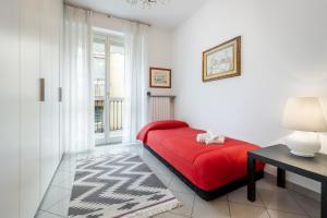 - un lit rouge dans une chambre avec fenêtre dans l'établissement Luce Apartment with free parking, à Alba