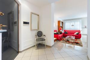 - un salon avec un canapé rouge et une chaise dans l'établissement Luce Apartment with free parking, à Alba
