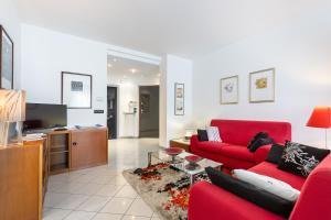 - un salon avec deux canapés rouges et une télévision dans l'établissement Luce Apartment with free parking, à Alba