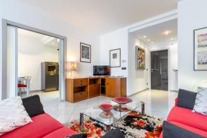 un salon avec un canapé rouge et une table dans l'établissement Luce Apartment with free parking, à Alba