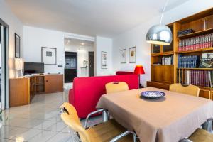 un salon avec une table et un canapé rouge dans l'établissement Luce Apartment with free parking, à Alba 23 autres photos
