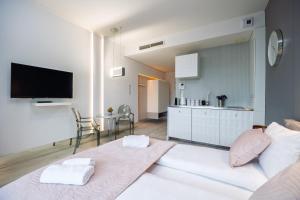 Una sala de estar con un sofá blanco y una cocina. en About Art Apartments - Ovo, en Wroclaw