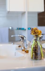a vase filled with flowers sitting on a kitchen sink at Villas Vilanija in Umag +37 photos