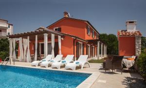 a house with a swimming pool and chairs next to it at Villas Vilanija in Umag