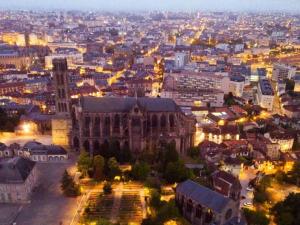 Blick auf die Stadt in der Nacht mit einem großen Gebäude in der Unterkunft La petite maison de l'étang in Magnac-Laval