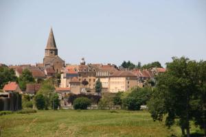 eine Gruppe von Gebäuden auf einem Feld mit einer Stadt in der Unterkunft La petite maison de l'étang in Magnac-Laval
