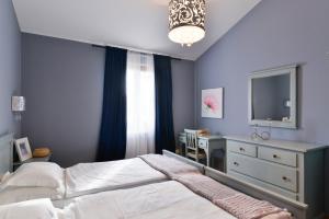 a bedroom with a bed and a dresser and a tv at Villas Vilanija in Umag
