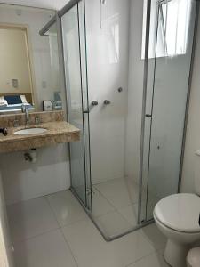a bathroom with a shower and a sink and a toilet at BARLOS HOTEL in Uruguaiana