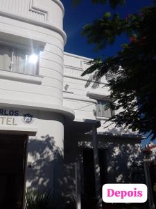 a white building with the sun shining in the window at BARLOS HOTEL in Uruguaiana +8 photos
