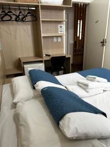 a bedroom with two beds with pillows on them at BARLOS HOTEL in Uruguaiana
