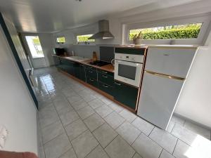 a kitchen with a refrigerator and a stove top oven at le pied marin in Lanchères