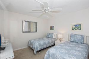 フォートマイヤーズビーチにあるPelican Watch #602 by Sun Palaceのベッド2台と天井ファン付きの寝室 +18枚の写真