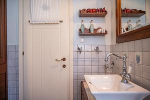 a bathroom with a sink and a white door at Emily's Luxury Suites in Pefkochori