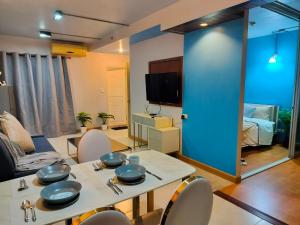 a living room with a table and chairs and a tv at ห้องพักสวยแสนสบาย in Ban Chek