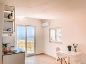 a kitchen and dining room with a table and a window at CILENTO BEACH house VISTA MARE in San Nicola