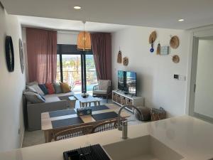 a living room with a couch and a table at Ayla Beach Apartment Azure 1522 Families only in Aqaba