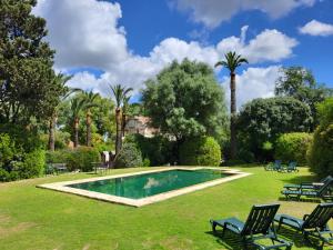 a swimming pool in a yard with chairs and trees at Casa Viña de Alcántara in Jerez de la Frontera