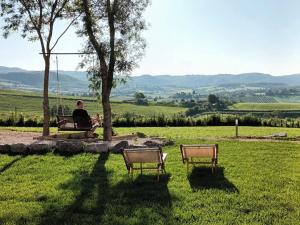萨杜勒尼亚Agriturismo Maremma Amara的坐在田野长凳上的男人