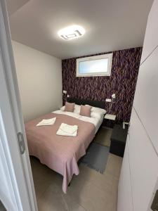 a bedroom with a bed with two towels on it at Holdfény apartman in Makó