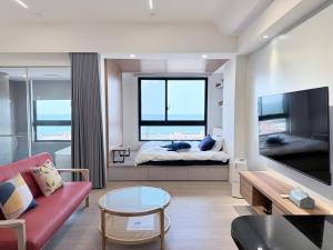 a living room with a bed and a large window at 海濱閣民宿 in Toucheng
