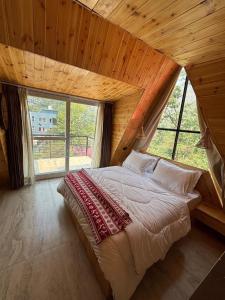 デヘラードゥーンにあるThe Brookside Bungalowの窓のある部屋にある大きなベッドのある寝室 +29枚の写真