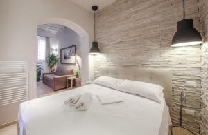 a bedroom with a white bed and a brick wall at Apartments Florence - Rosa piccolo in Florence