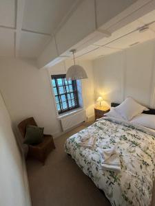 a bedroom with a bed and a chair and a window at St Cuthbert's Keep in Bedford