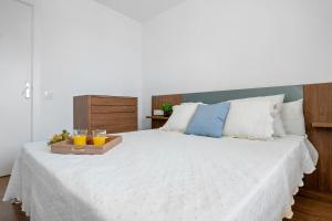 Una cama con una bandeja de naranjas y bebidas. en Apartamento TECAVI II, en La Pineda 13 fotos más