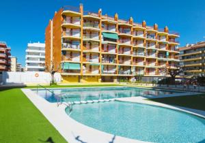 un hotel con piscina frente a un edificio en Apartamento TECAVI II, en La Pineda