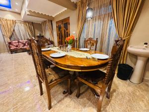 a dining room with a wooden table and chairs at Meraathanam in Jaffna