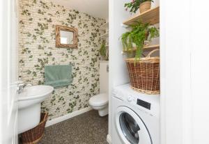 a bathroom with a washer and dryer next to a toilet at City Centre Haven in Perth