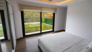a bedroom with a bed and large windows at Selimiye Mia Villa's in Selimiye +122 photos
