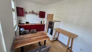 a kitchen with a wooden table and a kitchen with red cabinets at Gutenacht Bahnhof in Weimar