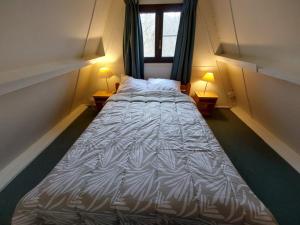 a large bed in a small room with two lamps at Chalet 230 I Gezellig chalet aan de rand van het bos - 5 persoons I Durbuy in Durbuy +31 photos