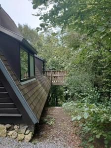 a house with a bridge over a dirt road at Chalet 230 I Gezellig chalet aan de rand van het bos - 5 persoons I Durbuy in Durbuy
