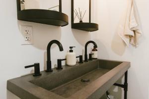 ein Badezimmer mit Waschbecken und zwei Wasserhähnen in der Unterkunft "Home Sweet Dome" MODERN TREEHOUSE STAY w/ Hot Tub in Rogers + 30 Fotos