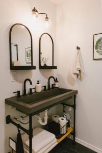 ein Badezimmer mit Waschbecken und zwei Spiegeln in der Unterkunft "Home Sweet Dome" MODERN TREEHOUSE STAY w/ Hot Tub in Rogers