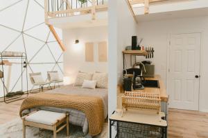 Schlafzimmer mit einem Bett, einem Tisch und einem Stuhl in der Unterkunft "Home Sweet Dome" MODERN TREEHOUSE STAY w/ Hot Tub in Rogers