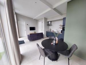 a living room with a table and chairs and a kitchen at Comfort bungalow 02 in Putten