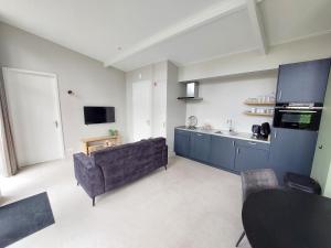 a living room with a couch and a kitchen at Comfort bungalow 02 in Putten