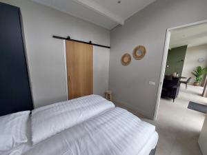 a bedroom with a white bed and a mirror at Comfort bungalow 02 in Putten