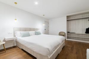 a large white bedroom with a large white bed at Casa Jazmin by Blossom Hotels in Granada