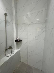 a white bathroom with a shower and a tub at Kinmen Xinya Homestay in Jinning +33 photos
