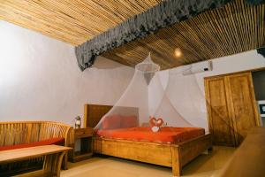 a bedroom with a bed with a curtain on it at Butterfly Beach Resort in Taytay