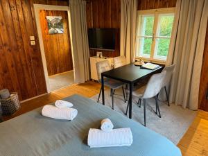 a living room with a table and chairs and a television at Auszeit im Holzhaus in Steinach am Brenner