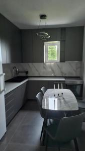 a kitchen with a table and chairs and a sink at Nuko's family in Nikšić